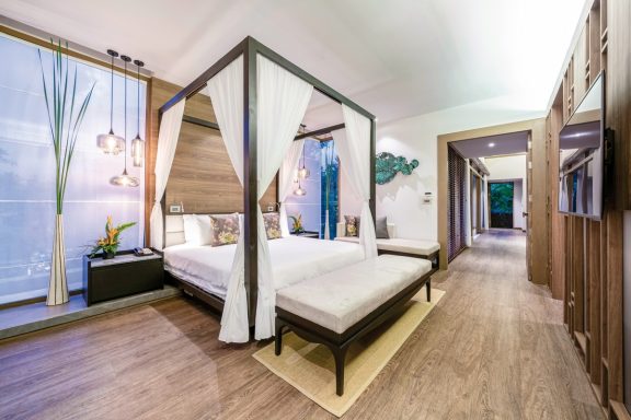 Elegantes Schlafzimmer mit Himmelbett und moderner Einrichtung. Helle Farben und luxuriöse Details.