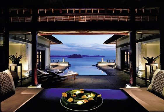 Blick auf eine luxuriöse Terrasse mit Meerblick bei Dämmerung.