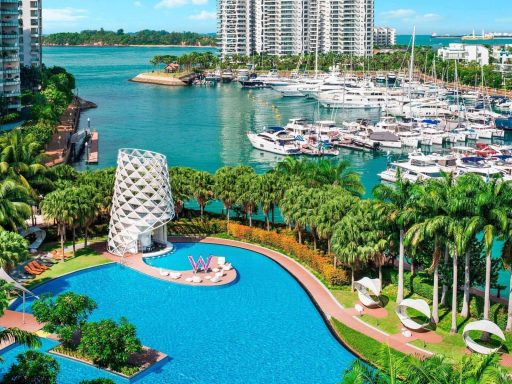 Luxuriöser Poolbereich mit Yachthafen und hohen Gebäuden im Hintergrund.