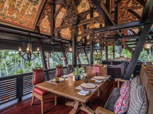 Holzinterieur mit Tisch, eleganten Stühlen und Ausblick auf grüne Landschaft.