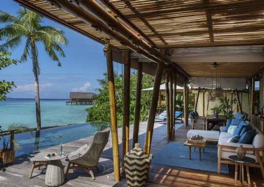 Moderne Strandvilla mit Stil, Luxusmöbeln und Blick auf das Meer und Palmen.
