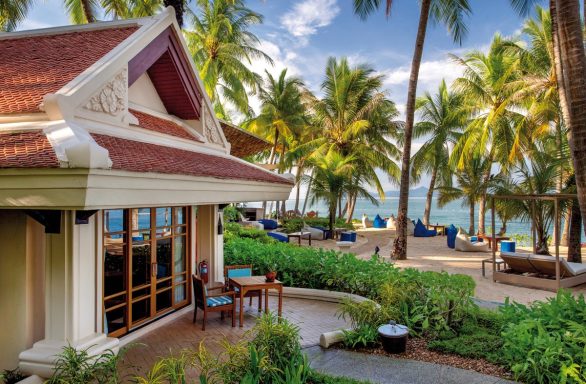 Tropische Landschaft mit Palmen, Meerblick und einem einladenden Gebäude.