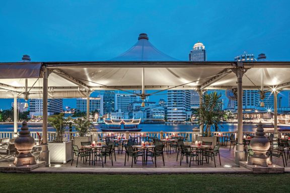 Elegante Terrasse mit Blick auf den Fluss und Stadtansicht bei Dämmerung.