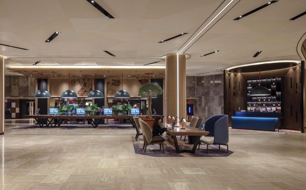 Moderne Lobby mit eleganten Möbeln, Pflanzen und einem Empfangstresen.